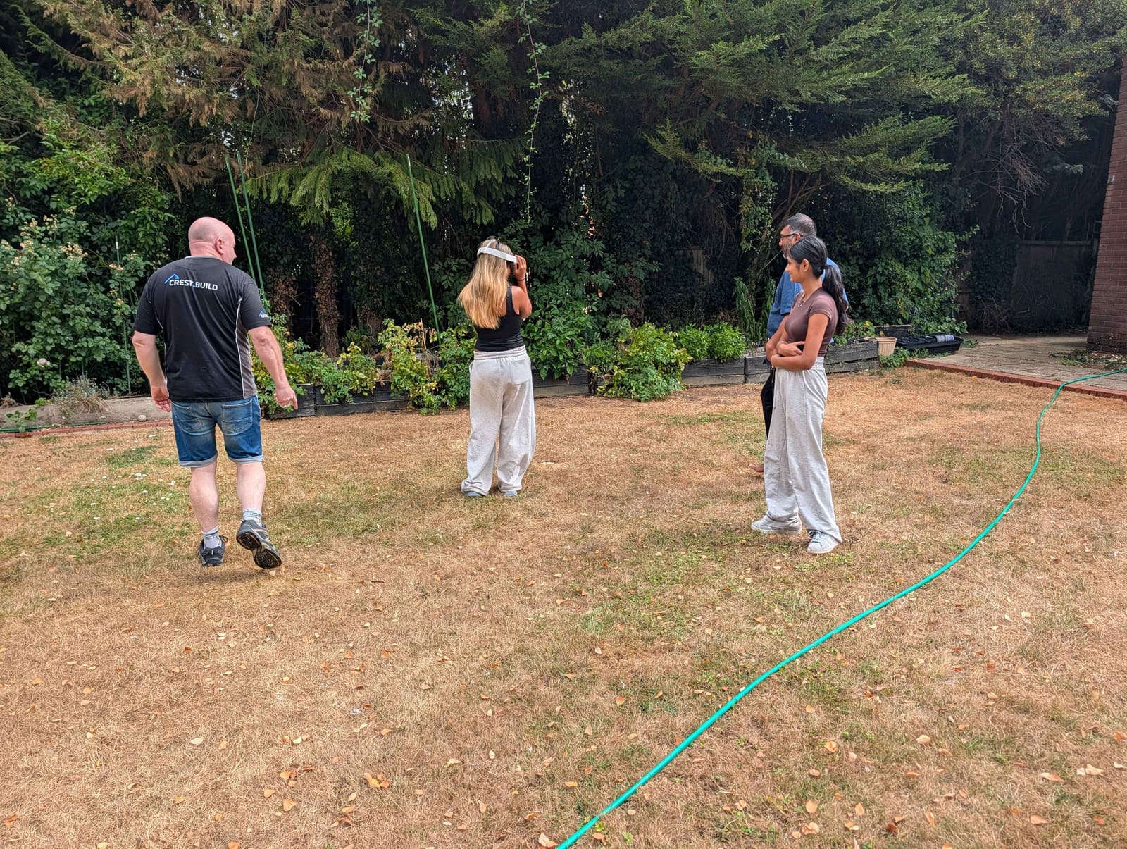 Family in their garden taking turns on a headset to walk a loft conversion and rear extension in AR