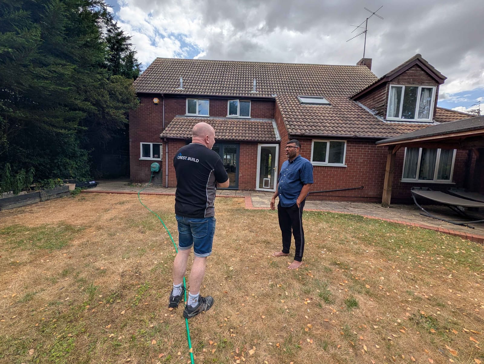 Builder and homeowner reviewing a house extension in augmented reality on site